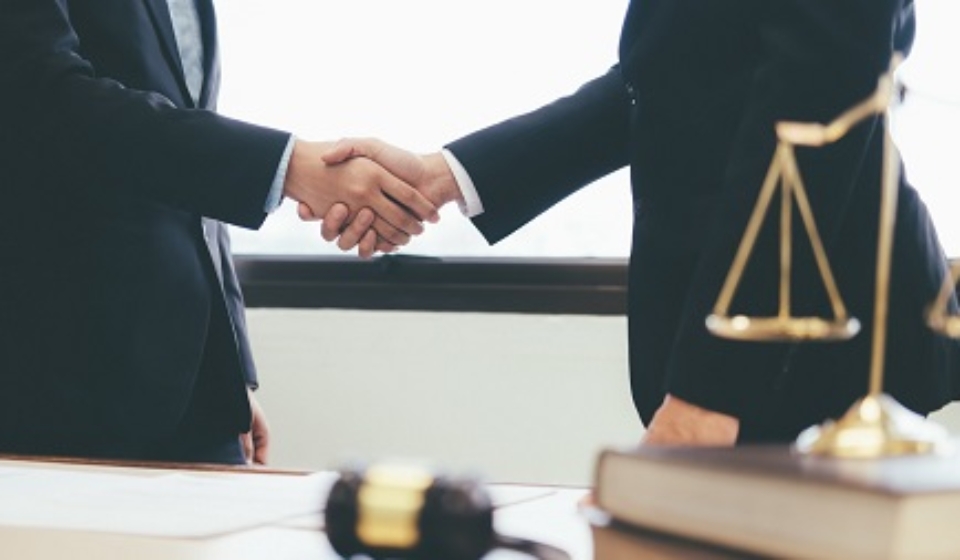 Law and Legal services concept. Lawyer and attorney having team meeting at law firm. Lawyer and businessman handshake.